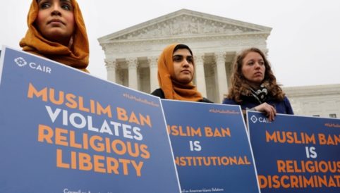 Three women protesting Muslim Ban