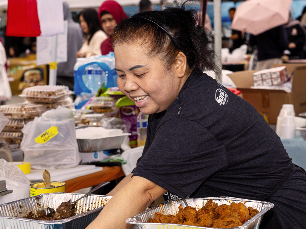 Woman serving food at the Global Muslim Village